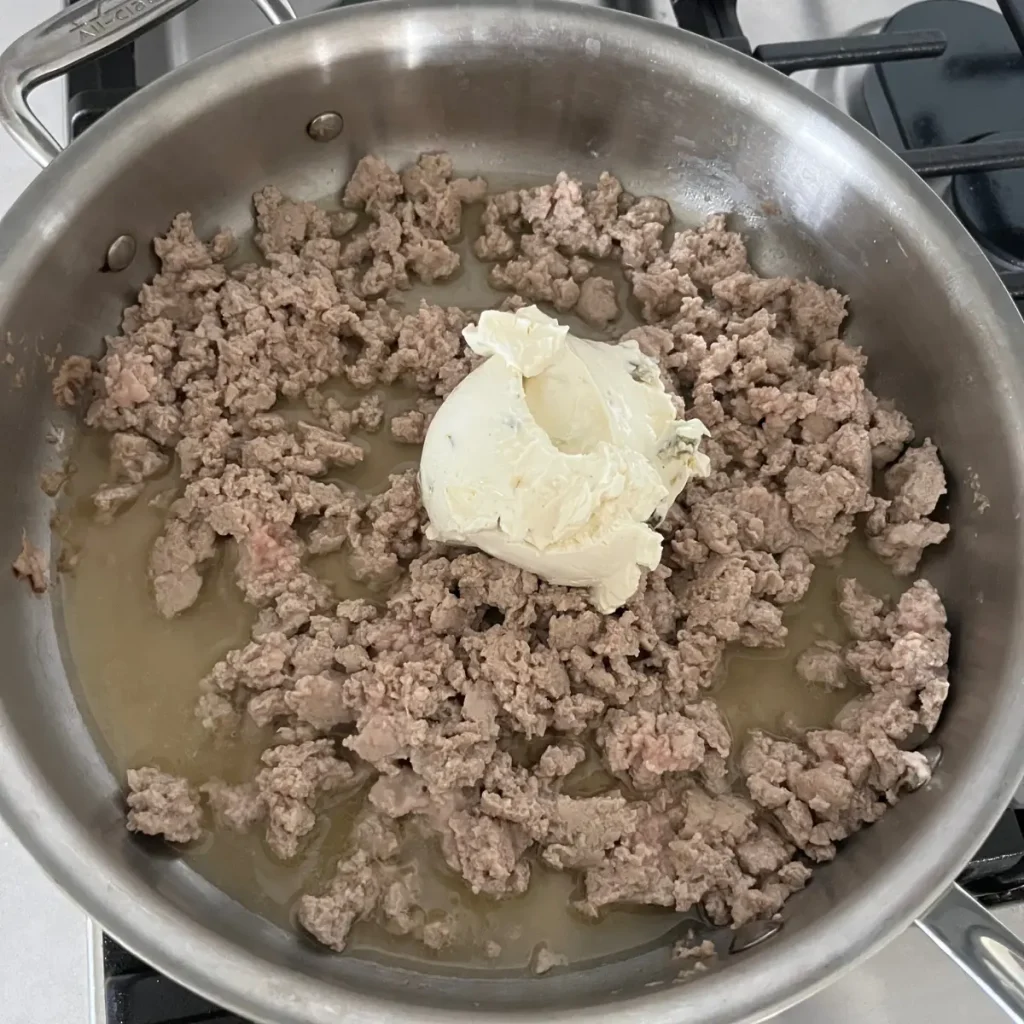 Ground turkey in a pan with cream cheese and chicken broth added in.