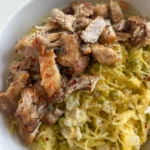 A fully assembled bowl of diced chicken thighs, spaghetti squash, and a cottage cheese Alfredo sauce.