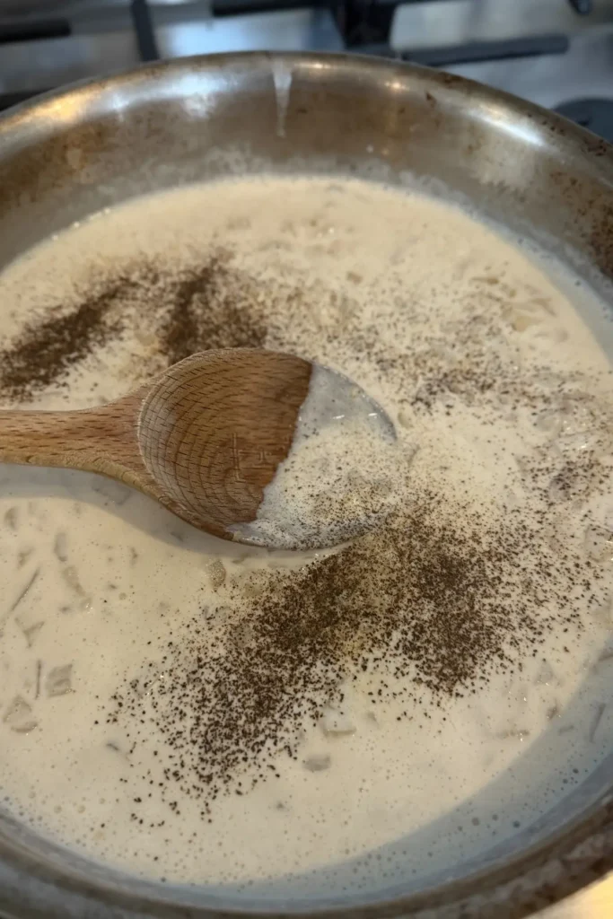 The cottage cheese sauce poured into a pan with black pepper.