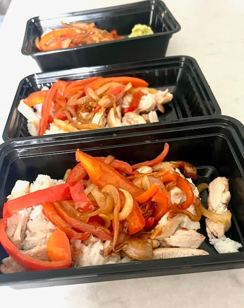 A chicken fajita bowl separated out into individual storage containers.