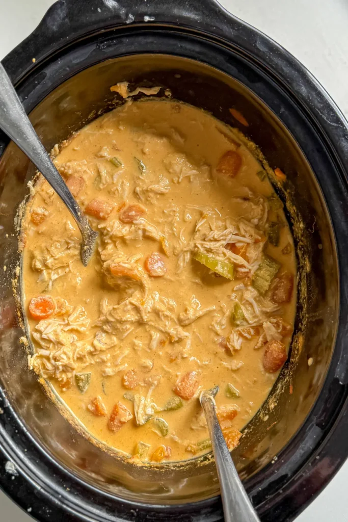 Shredding the chicken with two forks in the crockpot.