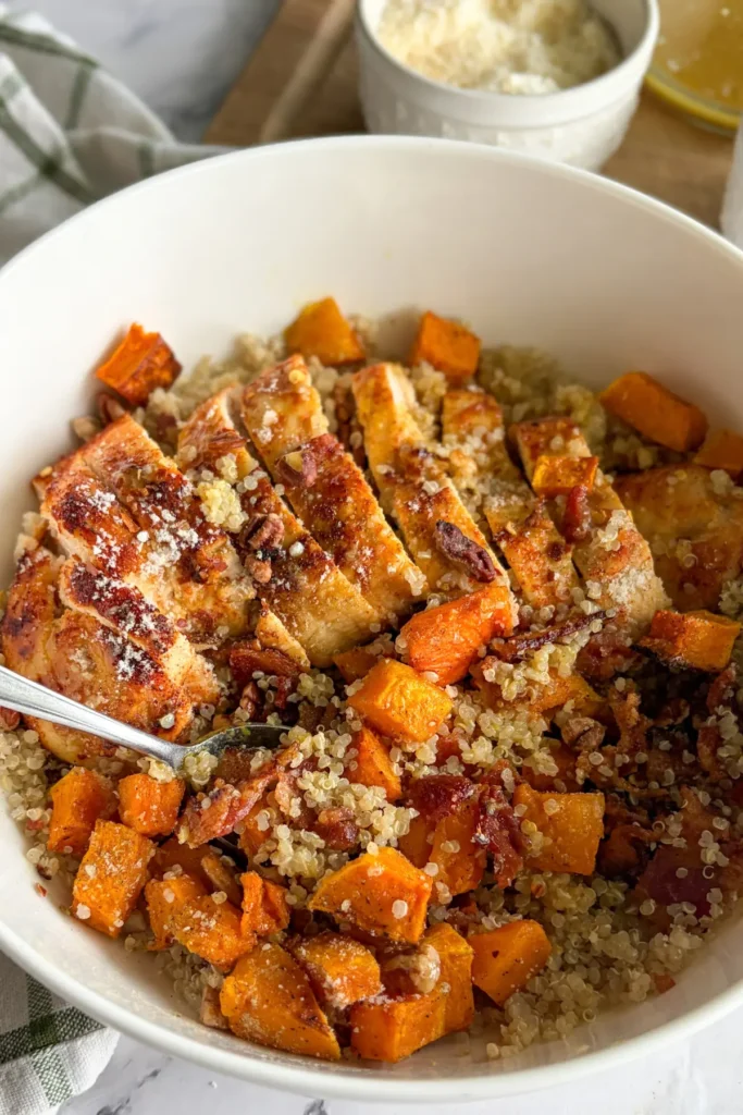 A fork digging into a plate with of parmesan quinoa bacon bowl.