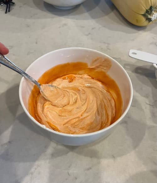 Mixing cottage cheese and buffalo sauce for buffalo chicken crockpot pasta.