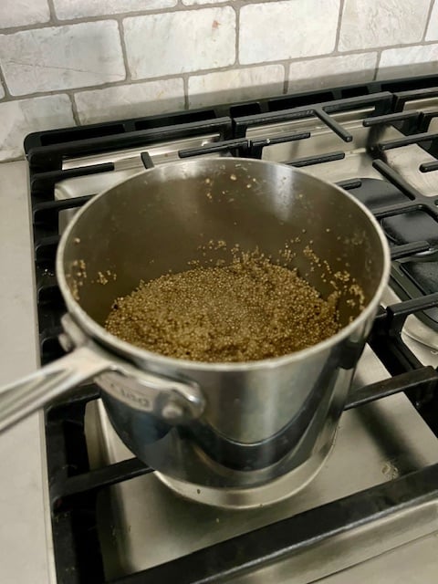 Cooking the Quinoa for Butternut Squash Quinoa Bowl in a pan on the stove.
