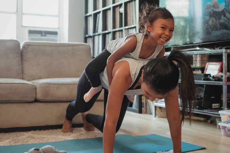 A mom and daugher working out together; home vs gym workouts
