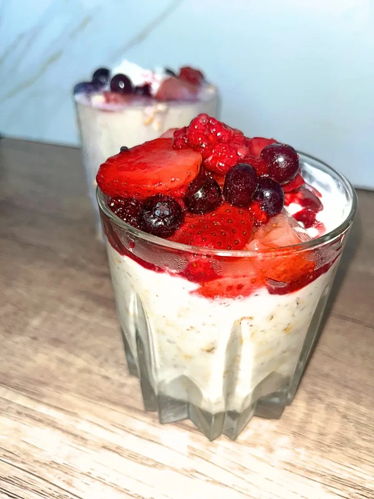 Two berry cheesecake overnight oats on a counter.