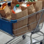 Bags of groceries in a grocery cart in a store.