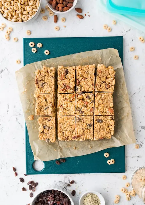 Individually cut trail mix bars on a cutting board.