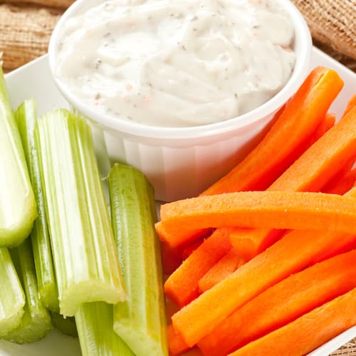 Sliced celery and carrots with a Greek yogurt dip for 7-day postpartum meal plan.