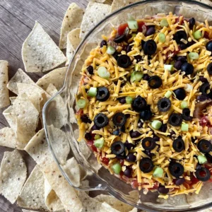 Cottage cheese taco dip in a glass pan with chips surrounding it on a counter.