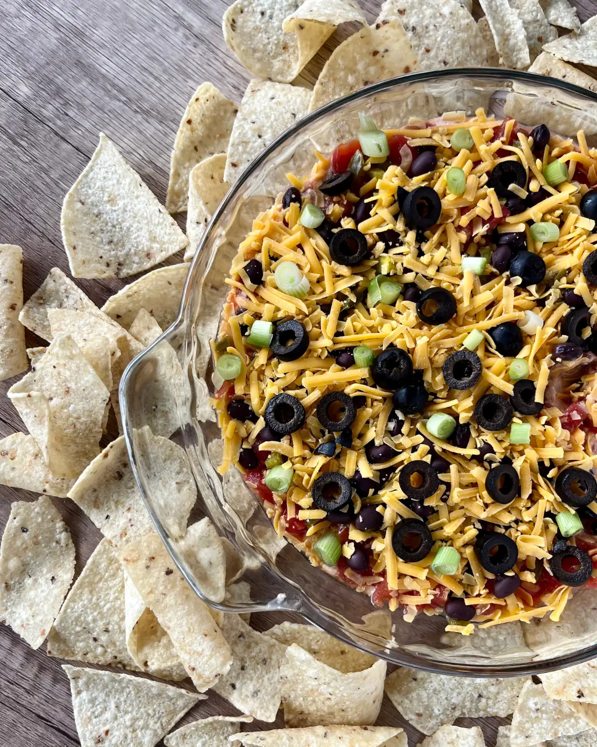 Cottage cheese taco dip in a glass pan with chips surrounding it on a counter.