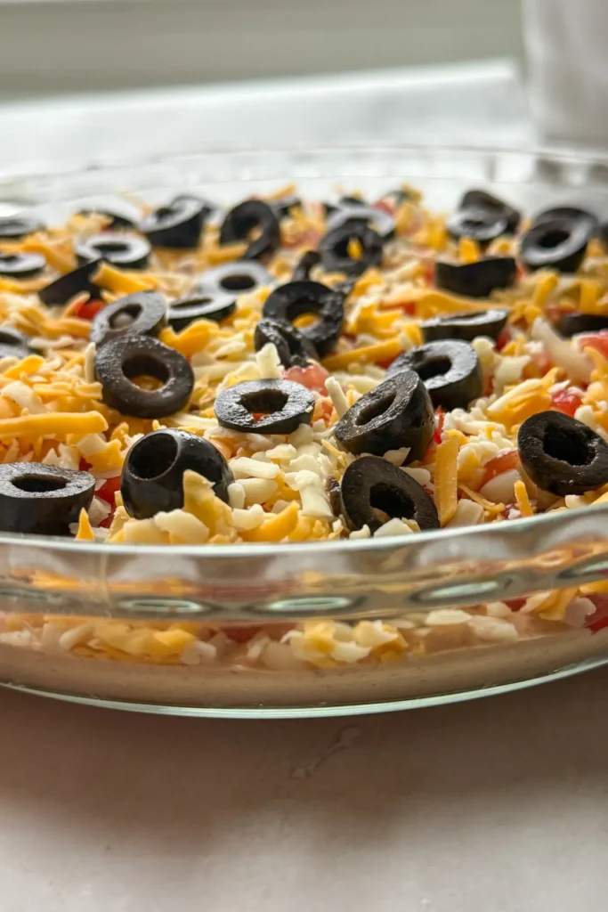 A side angle of the cottage cheese high protein dip in a round glass dish, showcasing each layer.