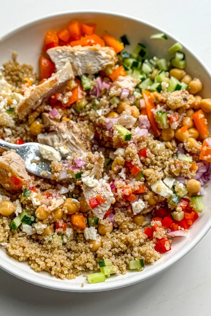 A close-up of a mixed together Mediterranean quinoa salad in a bowl.