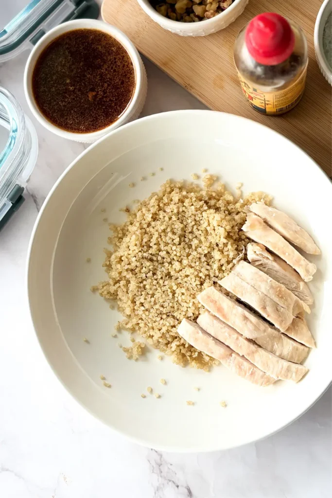 A birds-eye view of a bowl with quinoa and diced chicken on it.
