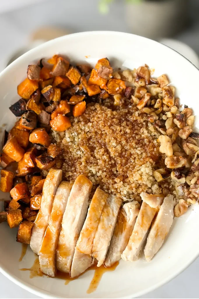 A close-up of a fully assembled chicken sweet potato bowl.