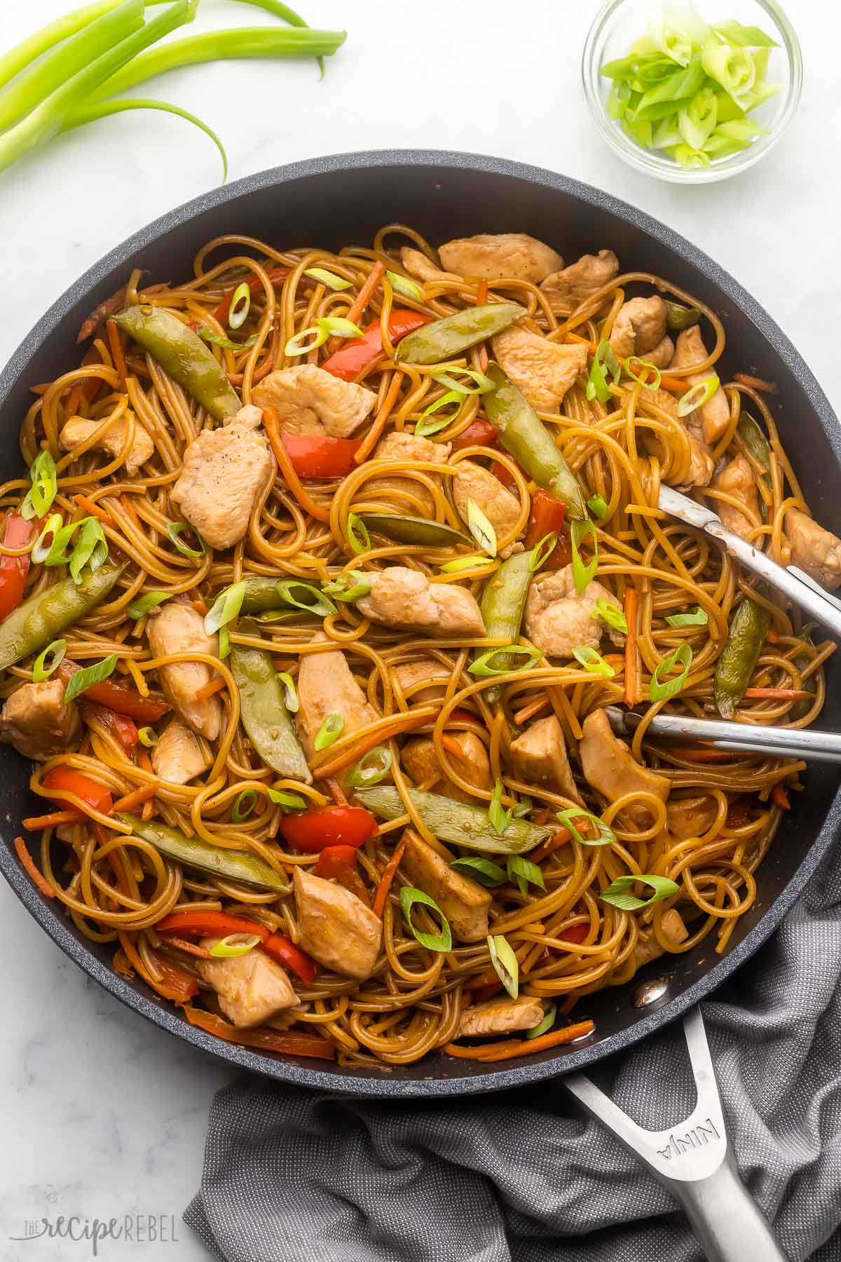 Teriyaki noodles, sliced chicken, and vegetables on a plate on the table for a lazy Sunday dinner idea.