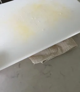 A cutting board on top of the tofu to press and drain it.