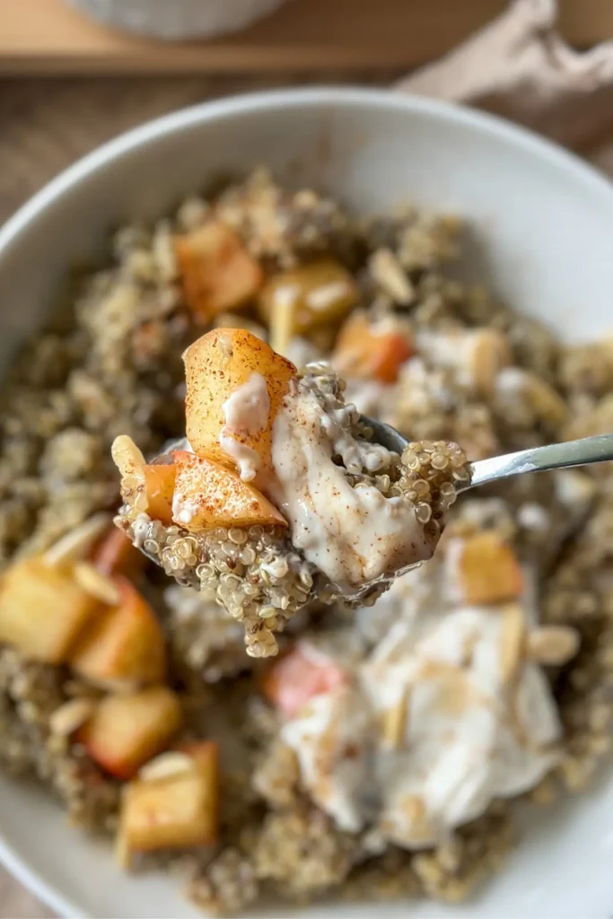A close-up of a big spoonful of quinoa, apples and the creamy cheesecake yogurt.