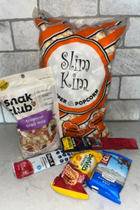 Popcorn, trail mix, and granola bars from the gas station on a counter in a kitchen.