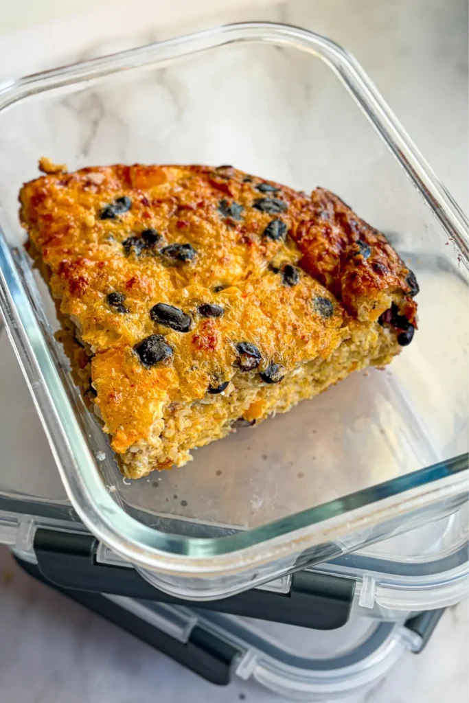 A slice of the quinoa breakfast bake in a glass storage container.