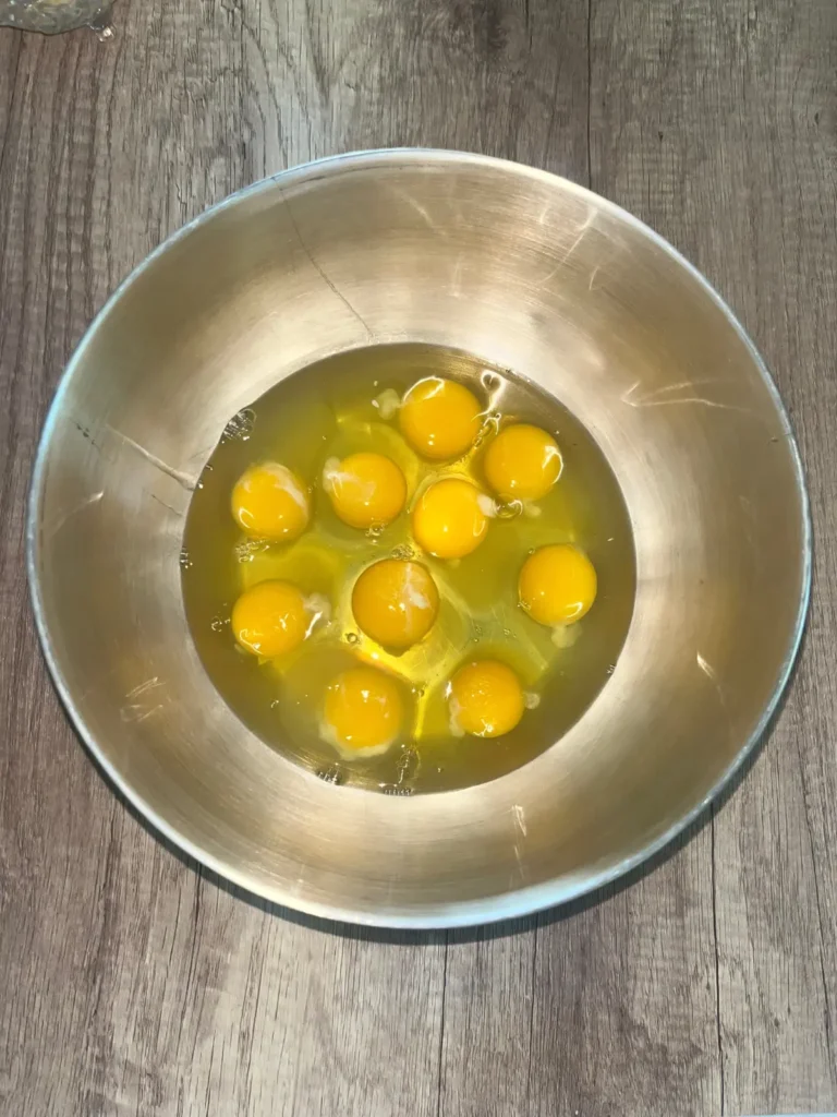 10 eggs cracked into a mixing bowl.