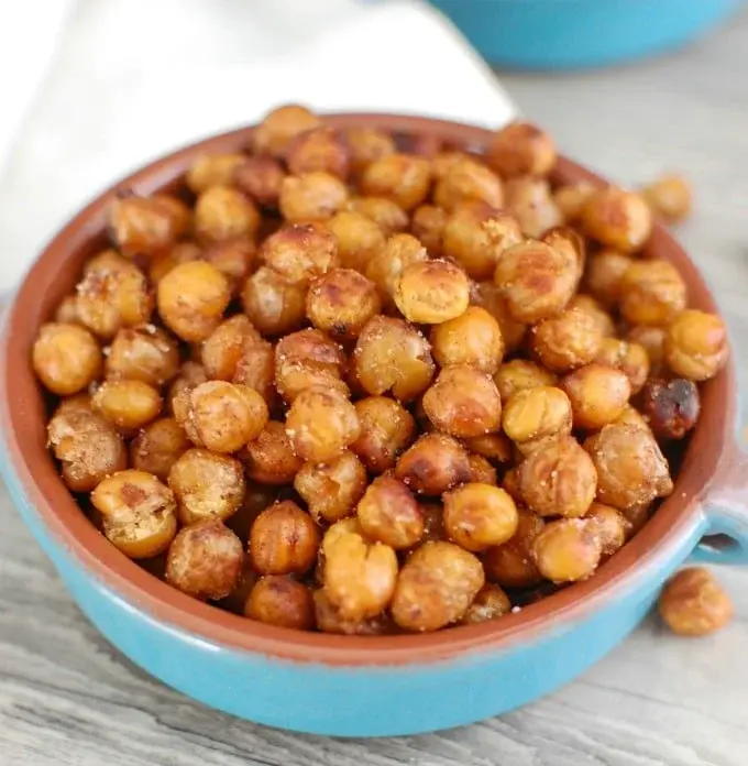 A bowl of crunchy roasted chickpeas on a counter.