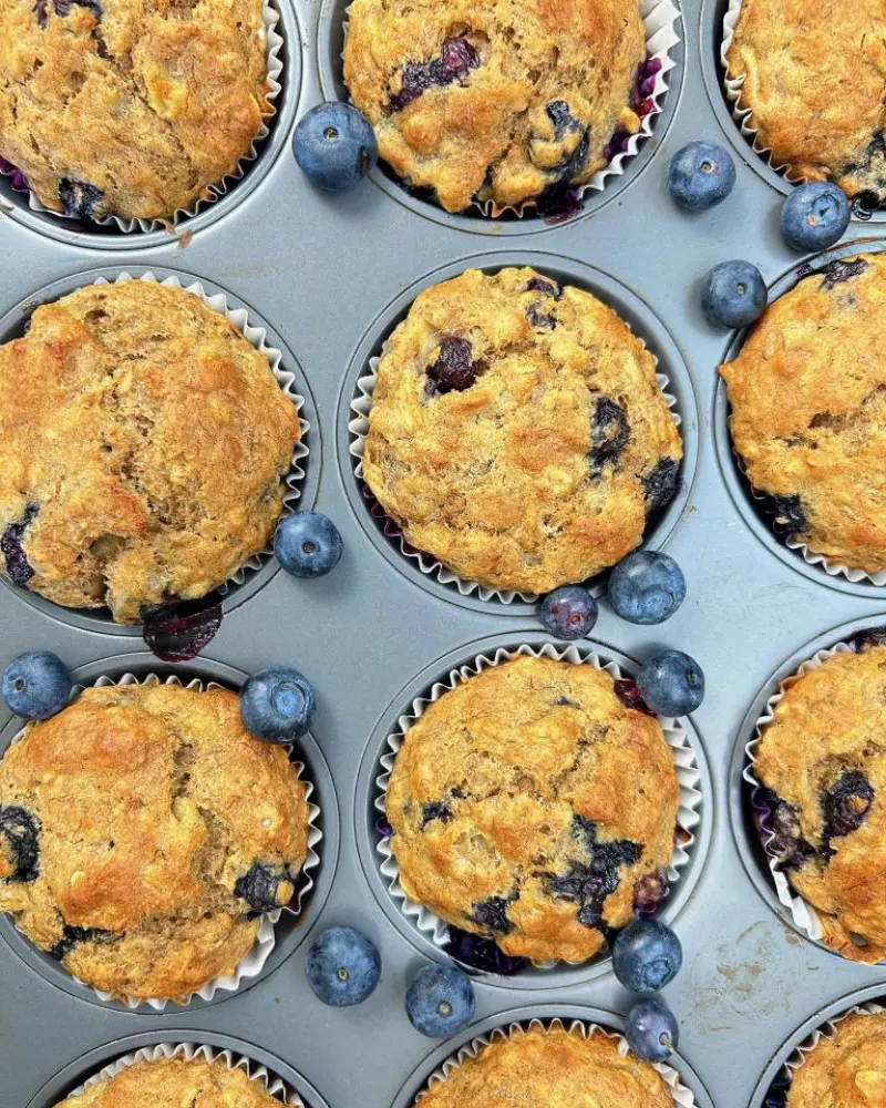 Blueberry oatmeal muffins in a muffin tin after baking.
