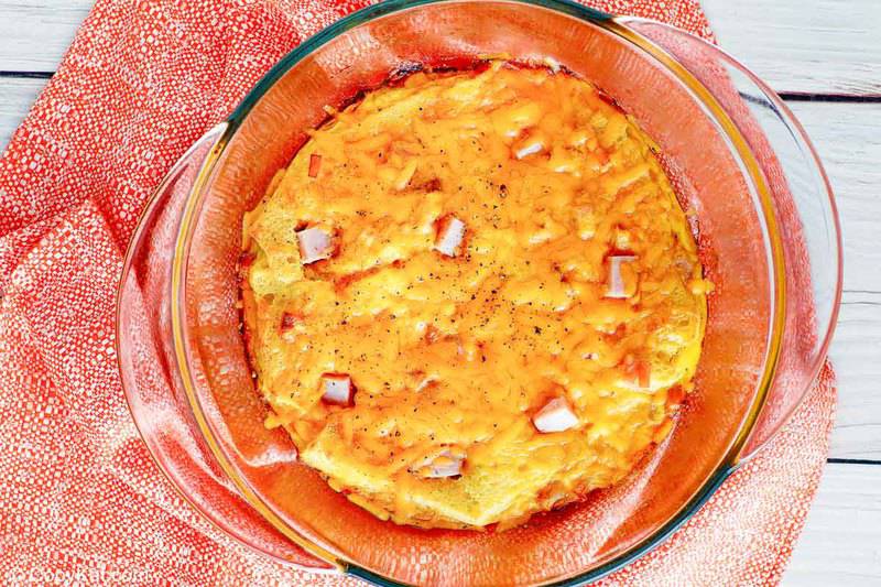 Crackers Barrel ham and cheese casserole in a glass baking dish on a pink towel.