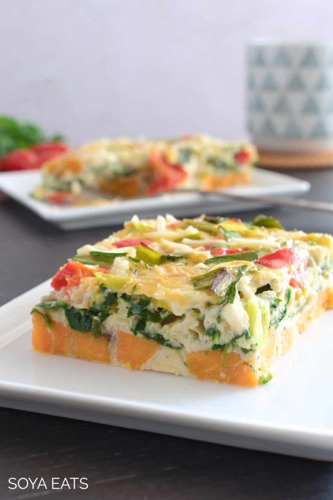 A slice of dairy-free breakfast casserole on a white plate on the table.