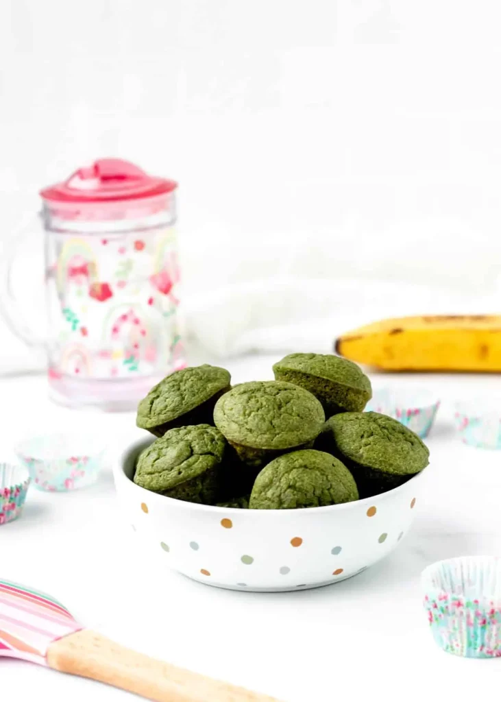 A bowl of green monster muffins on the counter.