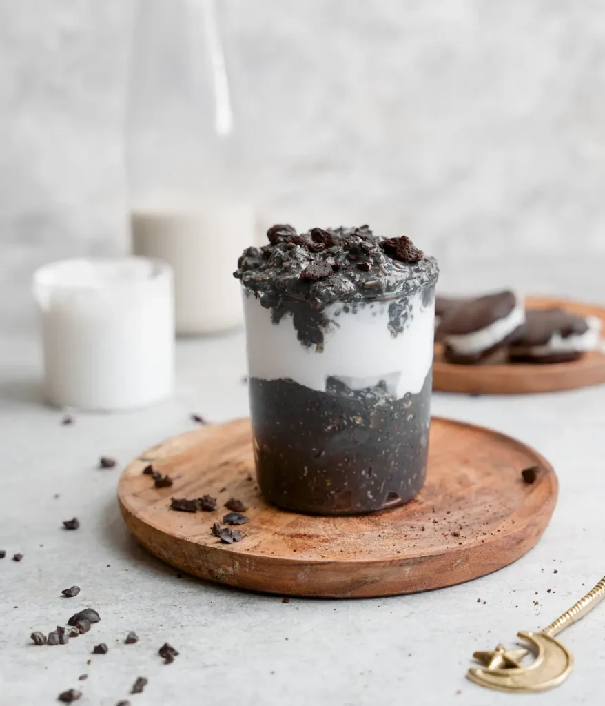 Cookies and cream overnight oats on a wooden plate on a dining table.