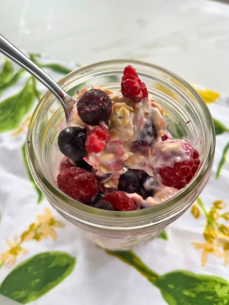 A close-up of a bite of creamy kefir overnight oats with lemon juice and berries.