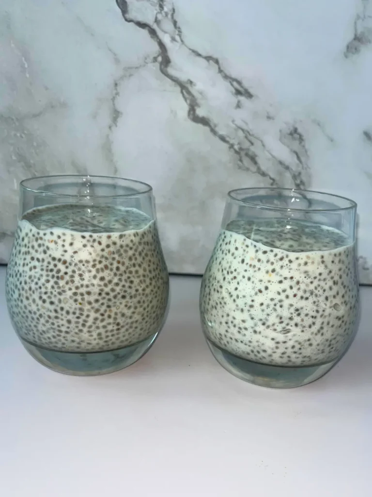 Two glasses filled with kefir chia pudding on a counter after refrigeration.