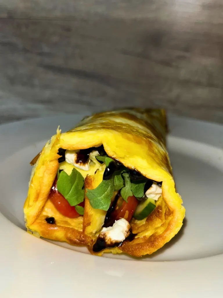 A rolled up arugula salad and cottage cheese flatbread on a plate.