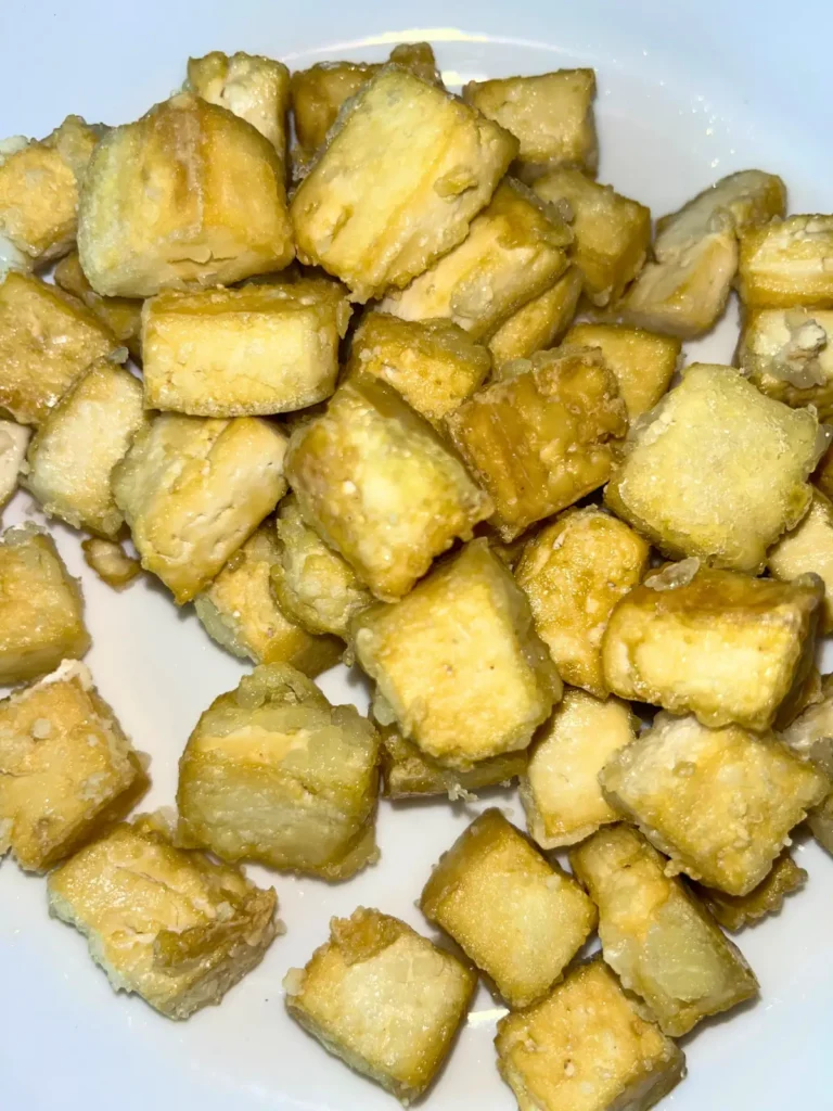 Crispy tofu bites piled up on a plate.