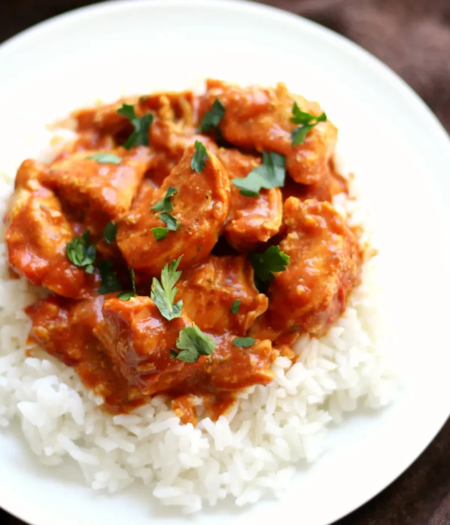 Dairy-free, gluten-free chicken tikka masala with white rice in a bowl.