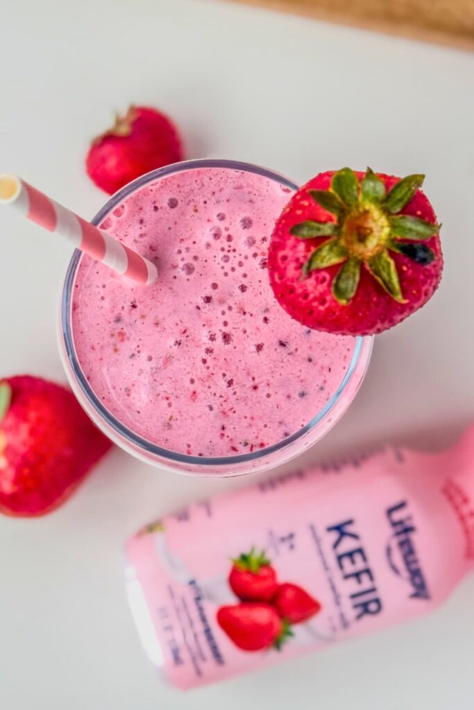 A strawberry probiotic kefir smoothie with a straw in it.