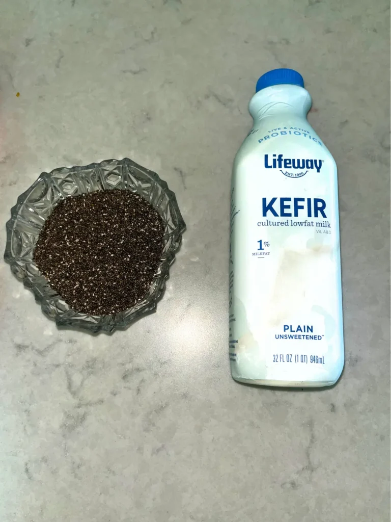 A bottle of Lifeway unflavored kefir next to a bowl of chia seeds on a counter.