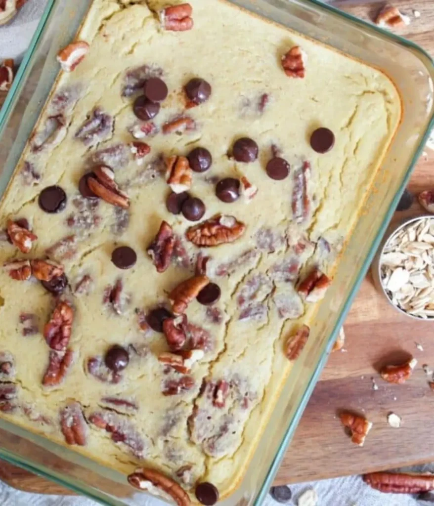 High protein baked outs in a glass baking dish topped with pecans on a counter.