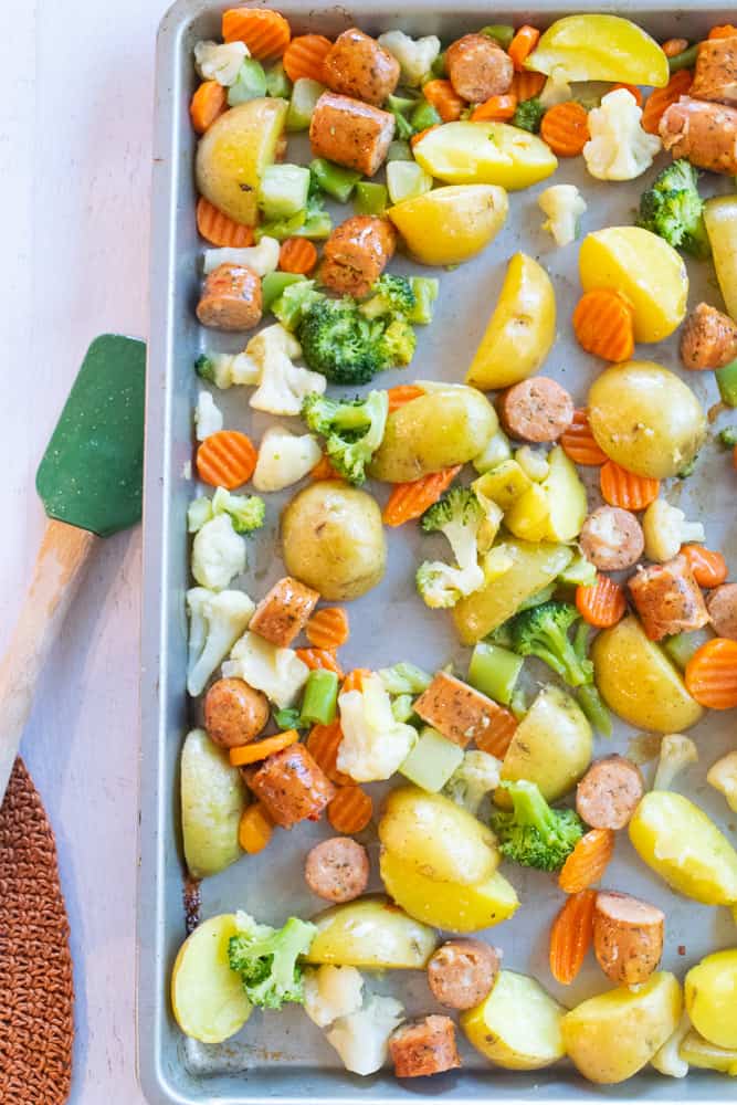 Sweet Italian sausage with veggies and potatoes on a sheet pan.