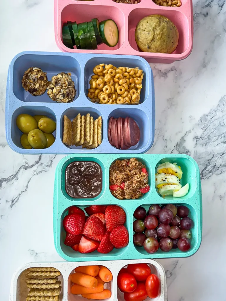 A birds-eye view of four snack boxes on a white counter.