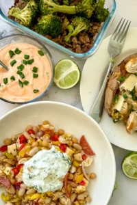 A birds-eye view of three easy dinners on a plate next to a Greek yogurt sauce on a table.