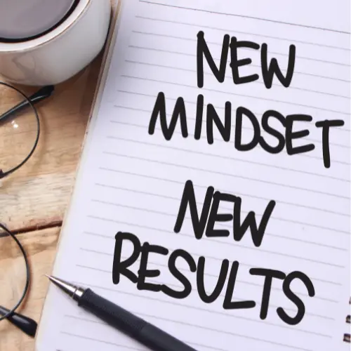 A piece of paper that says "new mindset, new results" with a pen on it on a table.