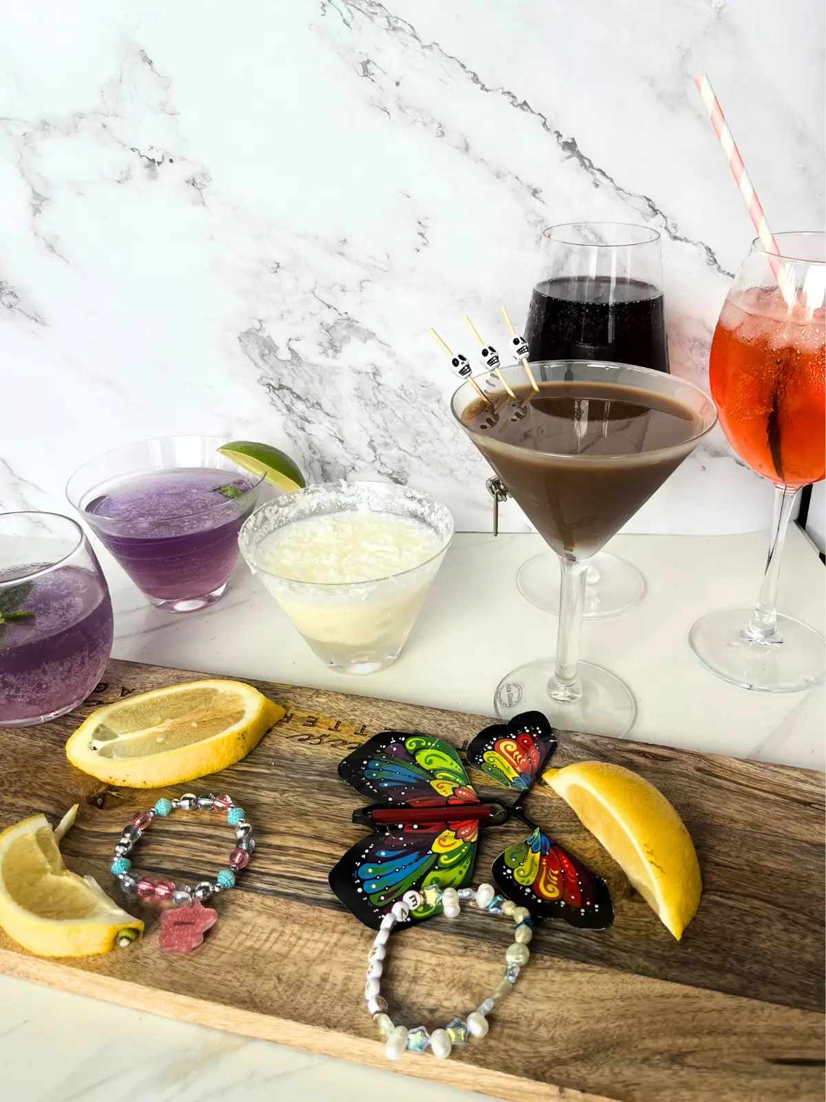 Taylor Swift inspired cocktails of various colors in glasses on a counter.