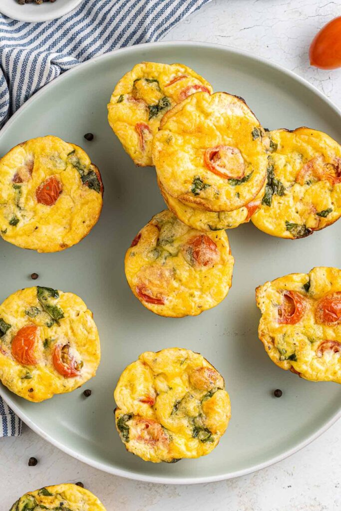 Tomato and basil egg bites arranged on a blue plate.