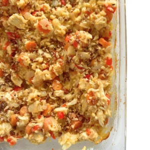 A birds-eye view of a creamy coconut chicken and rice casserole in a baking dish.