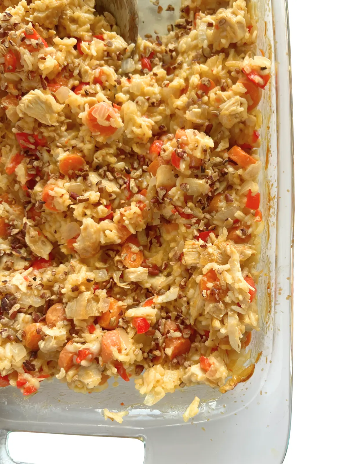 A birds-eye view of a creamy coconut chicken and rice casserole in a baking dish.