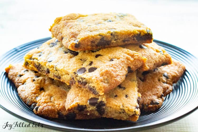 Chocolate chip cookie dough bars stacked on top of each other on a blue plate.