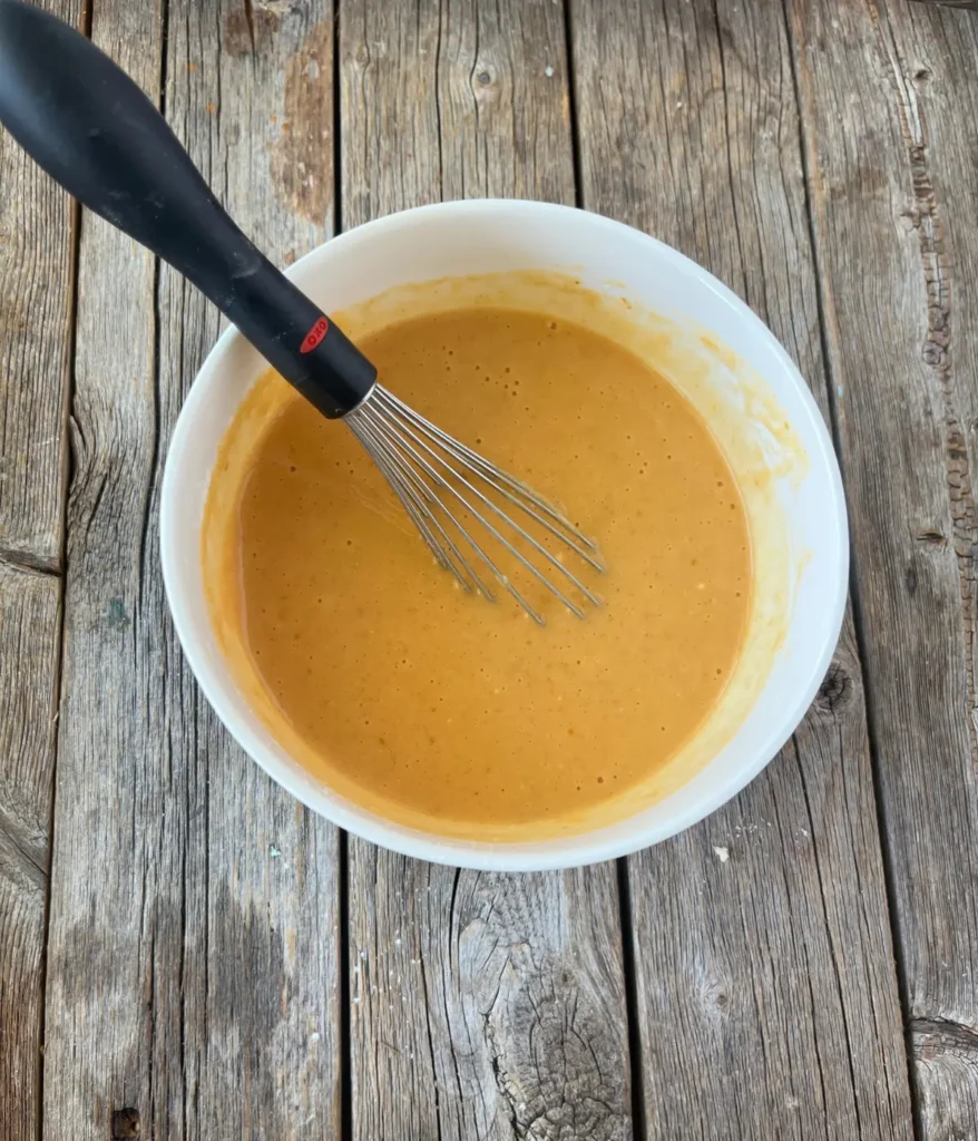 The pudding mixture whisked smoothly in a bowl.