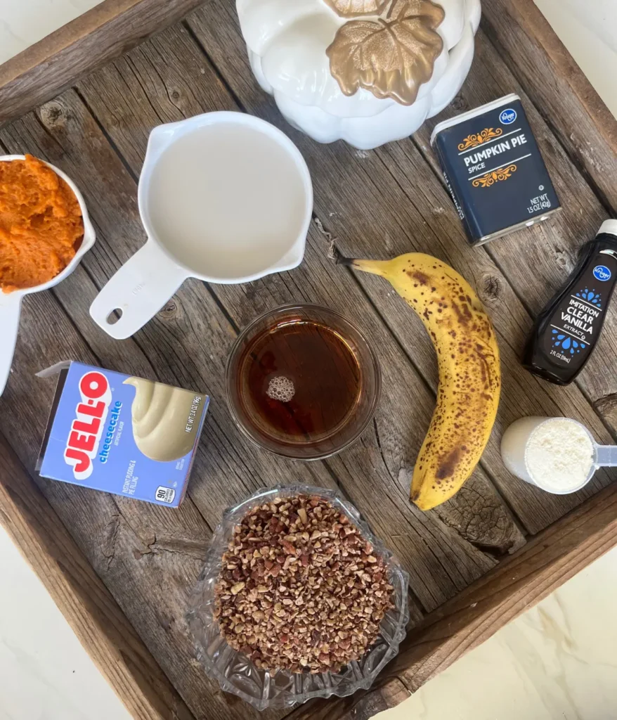 Ingredients for the healthy pumpkin cheesecake pudding on a wood cutting board.